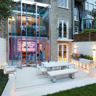Large contemporary back patio in London with an outdoor kitchen and no cover.