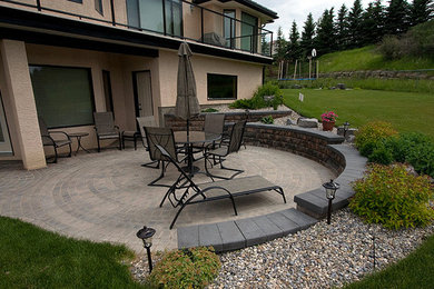 Immagine di un patio o portico dietro casa con un giardino in vaso e pavimentazioni in pietra naturale