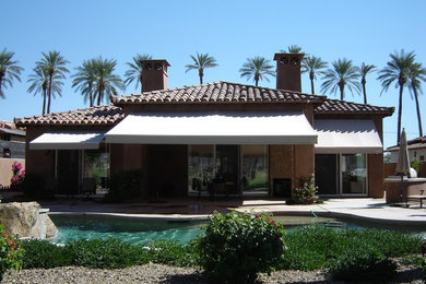 Diseño de patio mediterráneo grande en patio trasero con suelo de hormigón estampado y toldo