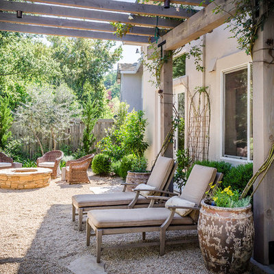 Example of a tuscan backyard decomposed granite patio design in Sacramento with a pergola
