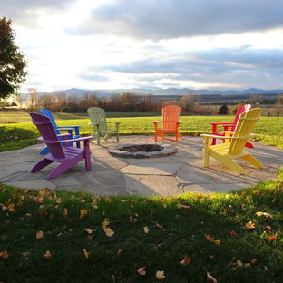 Patio - contemporary backyard stone patio idea in Burlington with a fire pit