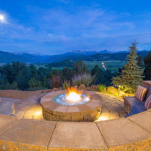 Esempio di un grande patio o portico rustico dietro casa con un focolare, pavimentazioni in pietra naturale e nessuna copertura