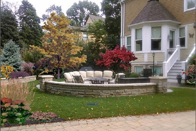 Modelo de patio tradicional grande sin cubierta en patio trasero con cocina exterior y adoquines de piedra natural