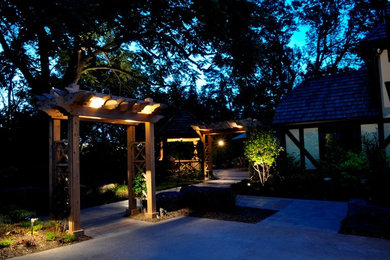 Diseño de patio clásico grande en patio lateral con adoquines de hormigón y pérgola