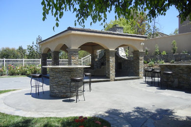 Inspiration for a large timeless backyard concrete paver patio kitchen remodel in Orange County with a gazebo