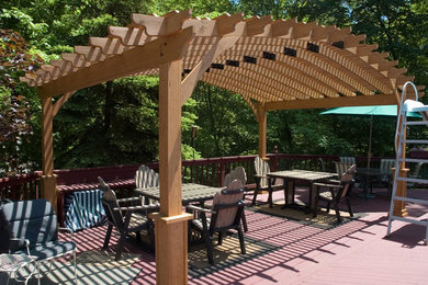 Example of a mid-sized backyard patio design in Cleveland with decking and a pergola