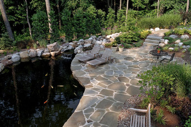 Inspiration for a backyard stone patio fountain remodel in Other