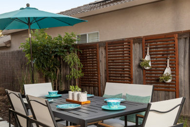 Imagen de patio actual de tamaño medio en patio trasero con cocina exterior, adoquines de hormigón y pérgola