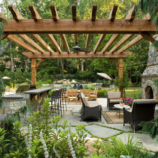 Foto di un patio o portico stile rurale dietro casa con pavimentazioni in cemento e una pergola
