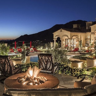 Foto di un ampio patio o portico mediterraneo dietro casa con pavimentazioni in pietra naturale e un gazebo o capanno