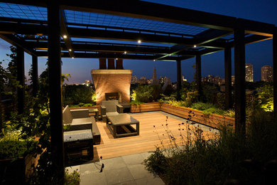 Example of a mid-sized minimalist backyard patio design in Chicago with a fire pit, decking and a pergola