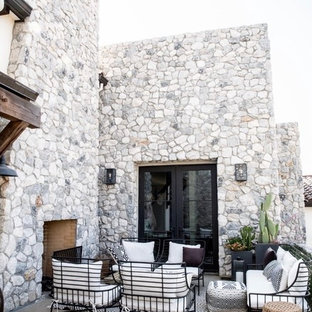 Foto di un patio o portico mediterraneo dietro casa con un caminetto, lastre di cemento e nessuna copertura