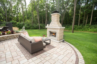 Inspiration for a large rustic backyard concrete paver patio remodel in Detroit with a fire pit