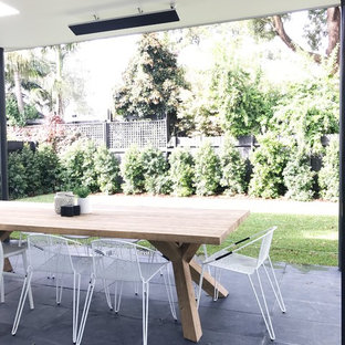 Foto di un grande patio o portico nordico dietro casa con pavimentazioni in pietra naturale