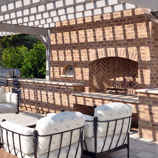 Immagine di un ampio patio o portico bohémian nel cortile laterale con pavimentazioni in pietra naturale e una pergola