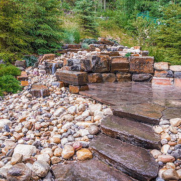 Rundle Stone Steps To Flagstone Patio Surrounded By Water Fall
