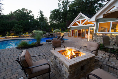 Mid-sized elegant backyard brick patio photo in New York with a fire pit and no cover
