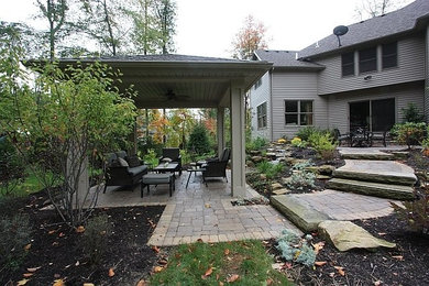 Large backyard concrete paver patio photo in Cleveland with a gazebo