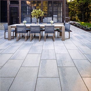 Immagine di un patio o portico stile rurale dietro casa con un focolare e lastre di cemento