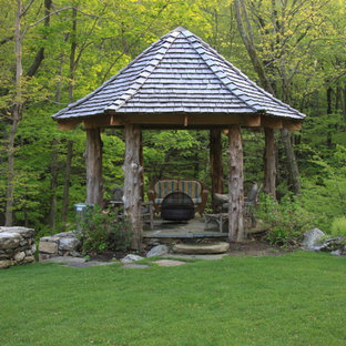 Inspiration for a rustic stone patio remodel in New York with a gazebo