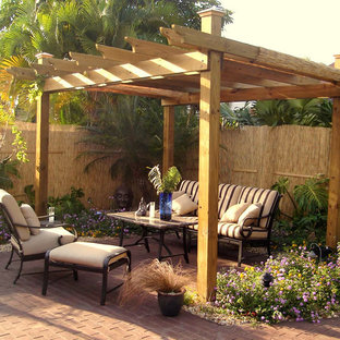 Ispirazione per un piccolo patio o portico stile rurale dietro casa con un giardino in vaso, pavimentazioni in mattoni e una pergola