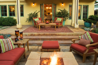 Ispirazione per un grande patio o portico mediterraneo dietro casa con un focolare, pavimentazioni in pietra naturale e nessuna copertura