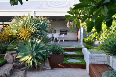 Foto de patio minimalista de tamaño medio en patio trasero y anexo de casas con cocina exterior y entablado
