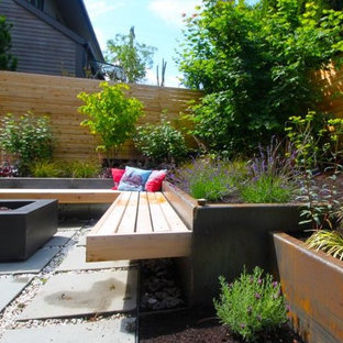 Idee per un grande patio o portico etnico dietro casa con un focolare, lastre di cemento e nessuna copertura