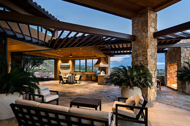 Patio - huge contemporary backyard stone patio idea in Phoenix with a fire pit and a roof extension