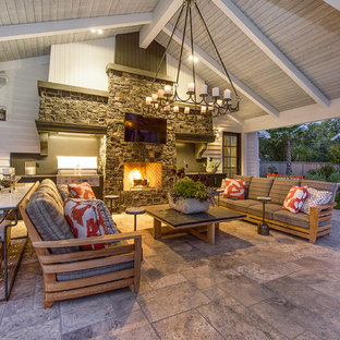 Esempio di un grande patio o portico country dietro casa con un caminetto, piastrelle e un gazebo o capanno