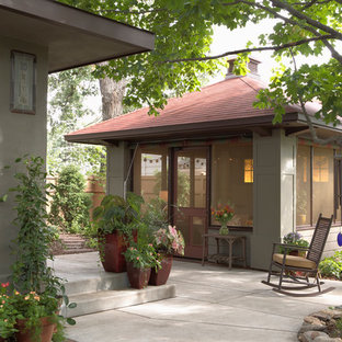 Immagine di un patio o portico stile americano dietro casa con lastre di cemento e un gazebo o capanno