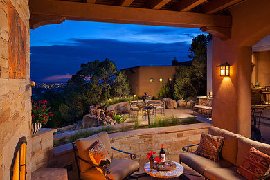 Inspiration for a large southwestern backyard stone patio kitchen remodel in Albuquerque with a roof extension