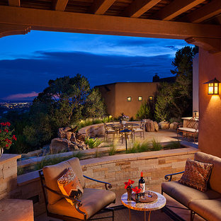 Esempio di un grande patio o portico american style dietro casa con pavimentazioni in pietra naturale e un tetto a sbalzo
