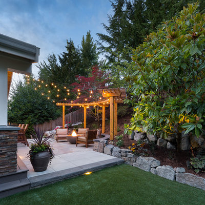 Inspiration for a large transitional backyard concrete paver patio remodel in Seattle with a fire pit