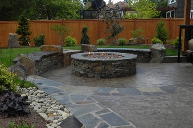 Mid-sized trendy backyard stamped concrete patio photo in Seattle with a fire pit
