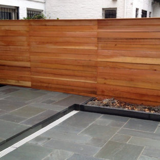 Idee per un piccolo patio o portico tradizionale dietro casa con piastrelle e un tetto a sbalzo