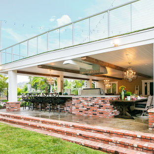 Huge farmhouse patio photo in Orange County with a roof extension