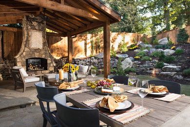 Inspiration for a large rustic backyard stone patio remodel in Atlanta with a fire pit and a gazebo