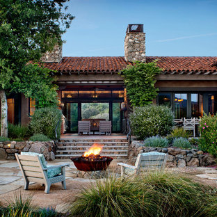Idee per un grande patio o portico stile americano dietro casa con un focolare, pavimentazioni in pietra naturale e nessuna copertura