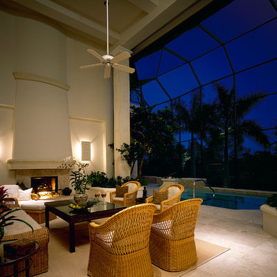 Elegant patio photo in Miami with a fire pit and a roof extension