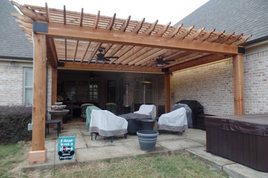 Inspiration for a large rustic backyard stamped concrete patio remodel in Other with a pergola