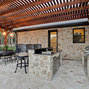 Foto di un grande patio o portico mediterraneo con una pergola e pavimentazioni in mattoni