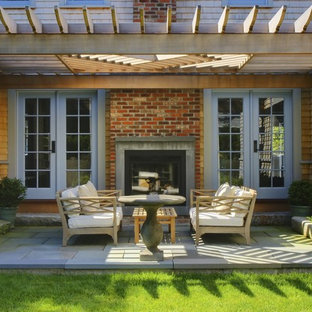 Idee per un patio o portico chic con un focolare e una pergola