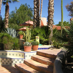 Foto di un ampio patio o portico stile americano dietro casa con pavimentazioni in pietra naturale e una pergola