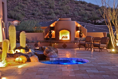 Photo of a large back patio in Phoenix with a fire feature, concrete paving and no cover.