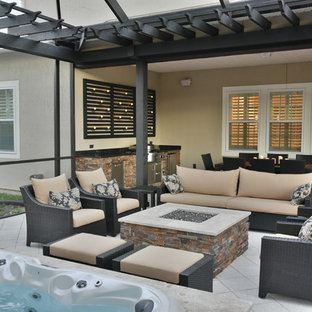 Patio kitchen - mid-sized tropical backyard tile patio kitchen idea in Jacksonville with a pergola