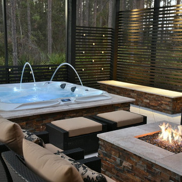 Screened area with sunken spa, fire pit and outdoor kitchen.