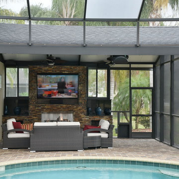 Screened in pool area addition with TV and fireplace.