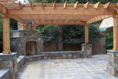 Foto de patio clásico de tamaño medio en patio trasero con adoquines de piedra natural y pérgola
