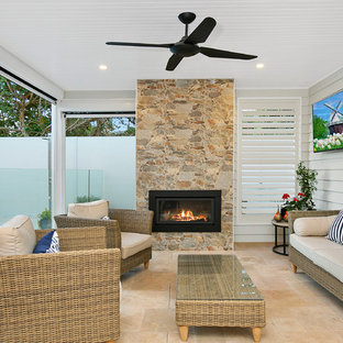 Inspiration for a beach style backyard patio in Melbourne with with fireplace and a roof extension.